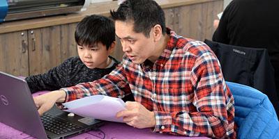 Picture of father and son using tech in Maker Place