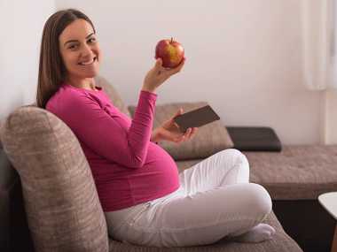 Pregnant woman eating an apple