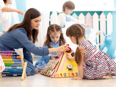 Girls at school playing with teacher