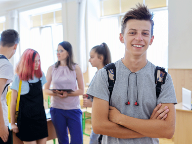 Boy stood in front of friends at school