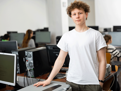 Older teen stood with computers