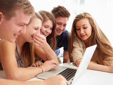 Teenage friends look at laptop