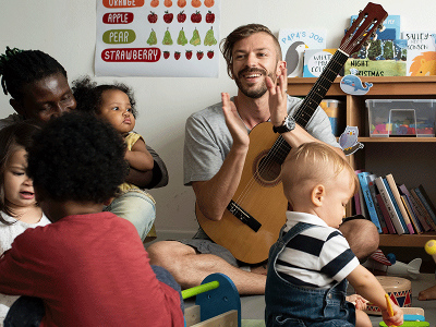 Male worker playing guitar in a school