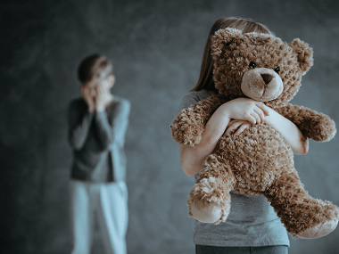 Scared child holds a teddy bear