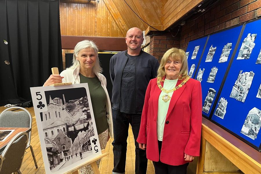 Artist Karen Rann, Graphic Designer Tommy Anderson and the Mayor of Gateshead Councillor Kath McCartney stand round a large playing card.