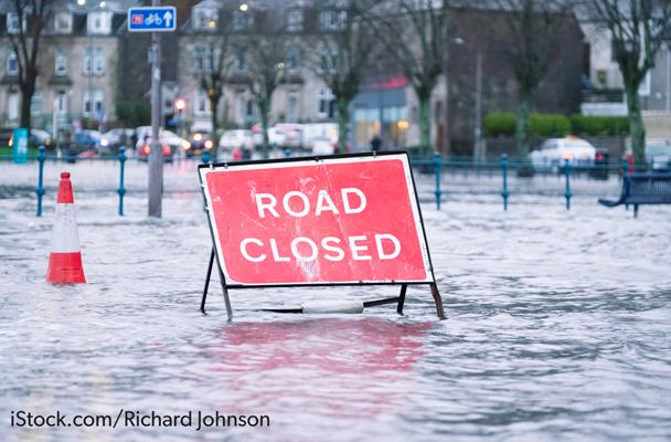 A road closed sign surrounded by flood water